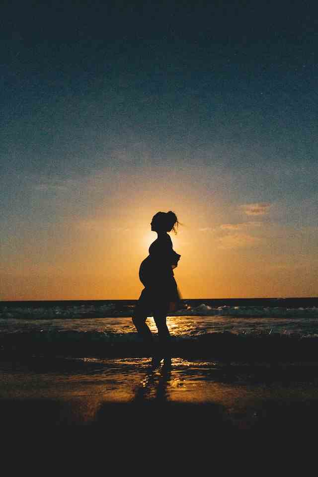 海辺を歩く妊婦